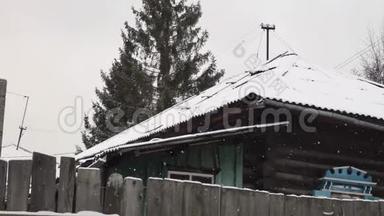 村子里下雪了。 篱笆后面的旧木房子
